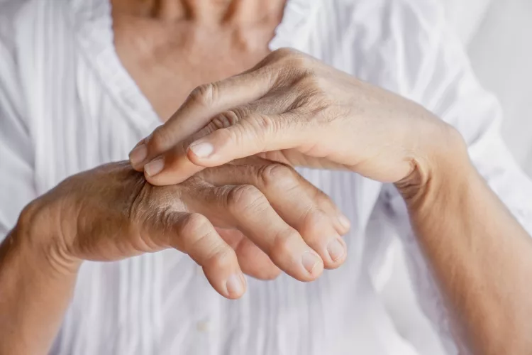 female patient massaging hand and fingers having problem with gout and joint pain